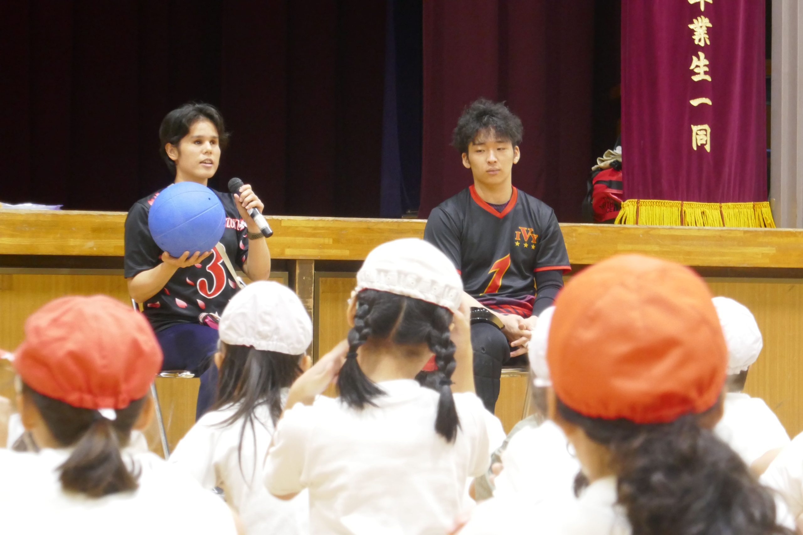 講演会でゴールボールを手に持って話をする安室早姫選手と永野陽希選手