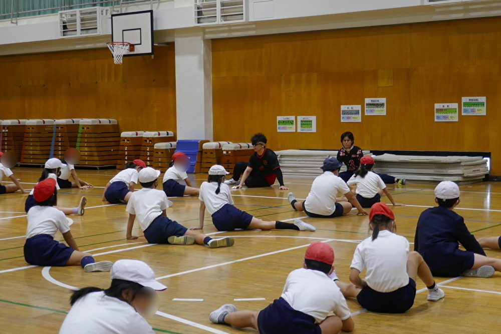 安室早姫選手と永野陽希選手と一緒にゴールボールのディフェンスの練習をする児童