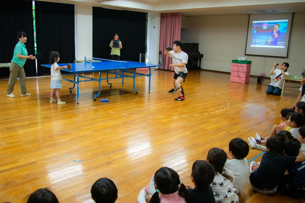 子どもが構えるラケットを目掛けて、岩渕幸洋選手が卓球ボールを打つ