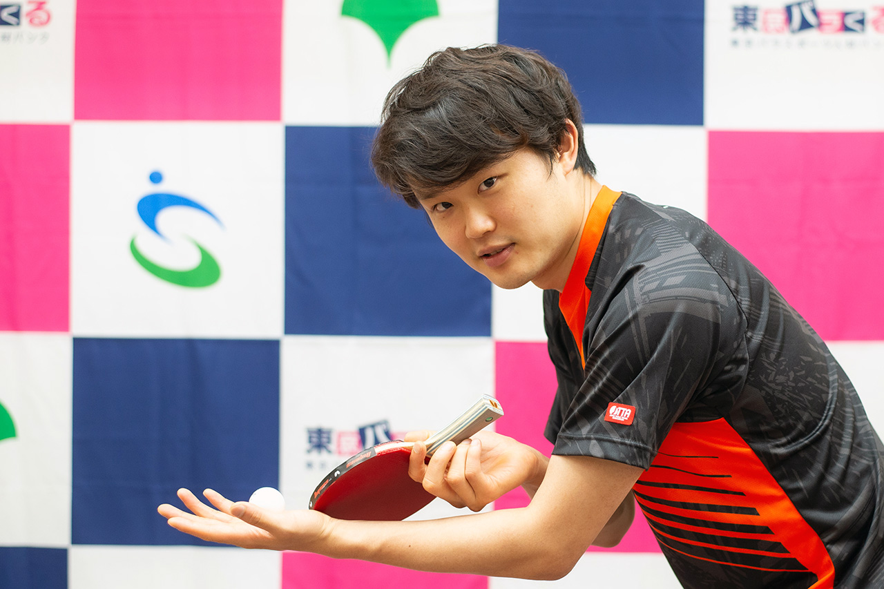 灘光選手が立ち上がり、マイクを握って講演会で話している