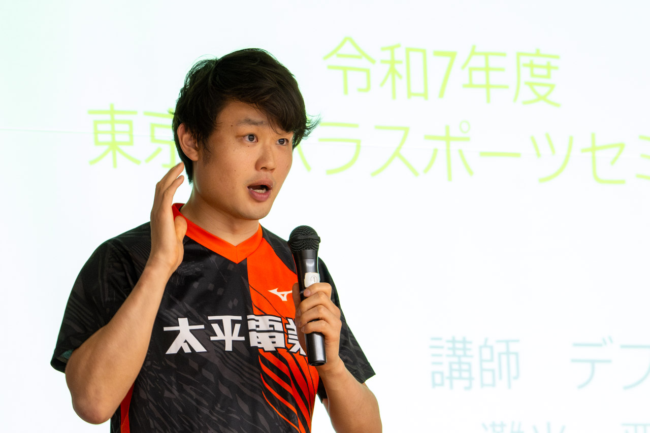 灘光選手が立ち上がり、マイクを握って講演会で話している