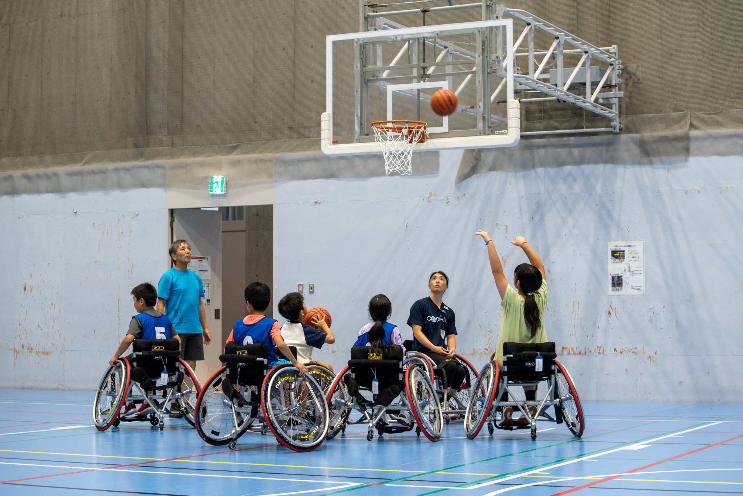 網本麻里選手が小学生と一緒に車いすバスケットボールを楽しんでいる