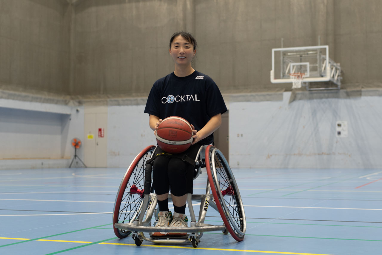 網本麻里選手ポートレート、競技用車いすに乗って微笑んでいる